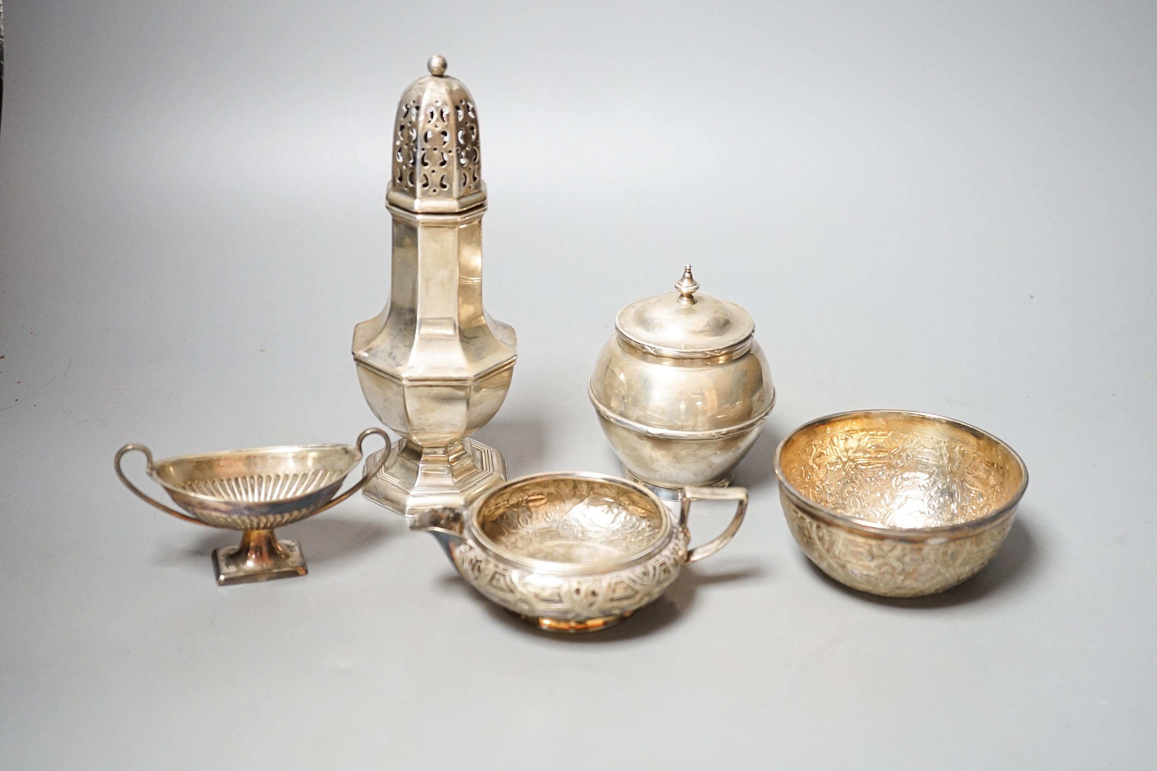 A George V silver sugar caster, 18cm, a silver globular pot with hinged cover, 9oz, a silver plated cream jug, sugar bowl, salt and spoon.